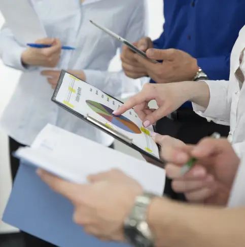 Grupo de personas revisando documentos financieros, representación de outsourcing y gestión de sueldos.